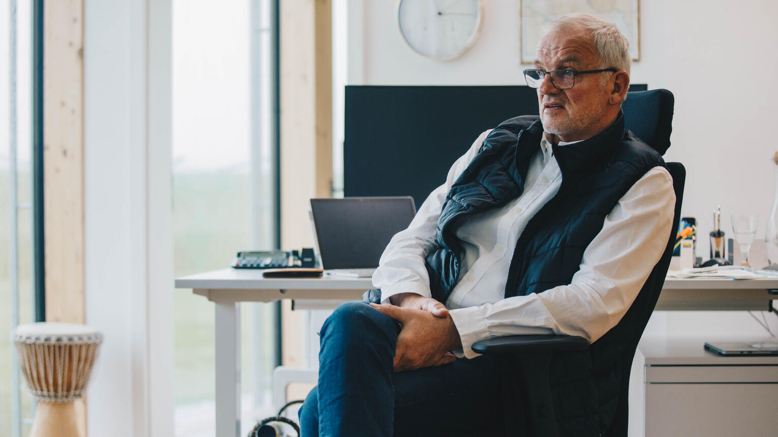 Dirk Ketelsen sitzt auf einem Schreibtischstuhl in einem modernen, hellen Raum.